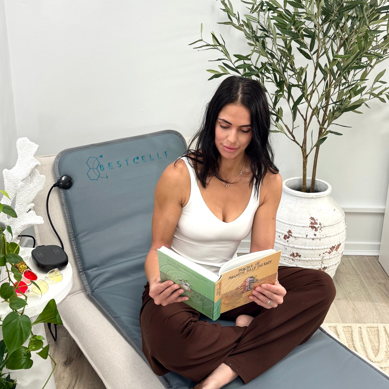 Stephanie reading on the BEST CELLF PEMF therapy Mat