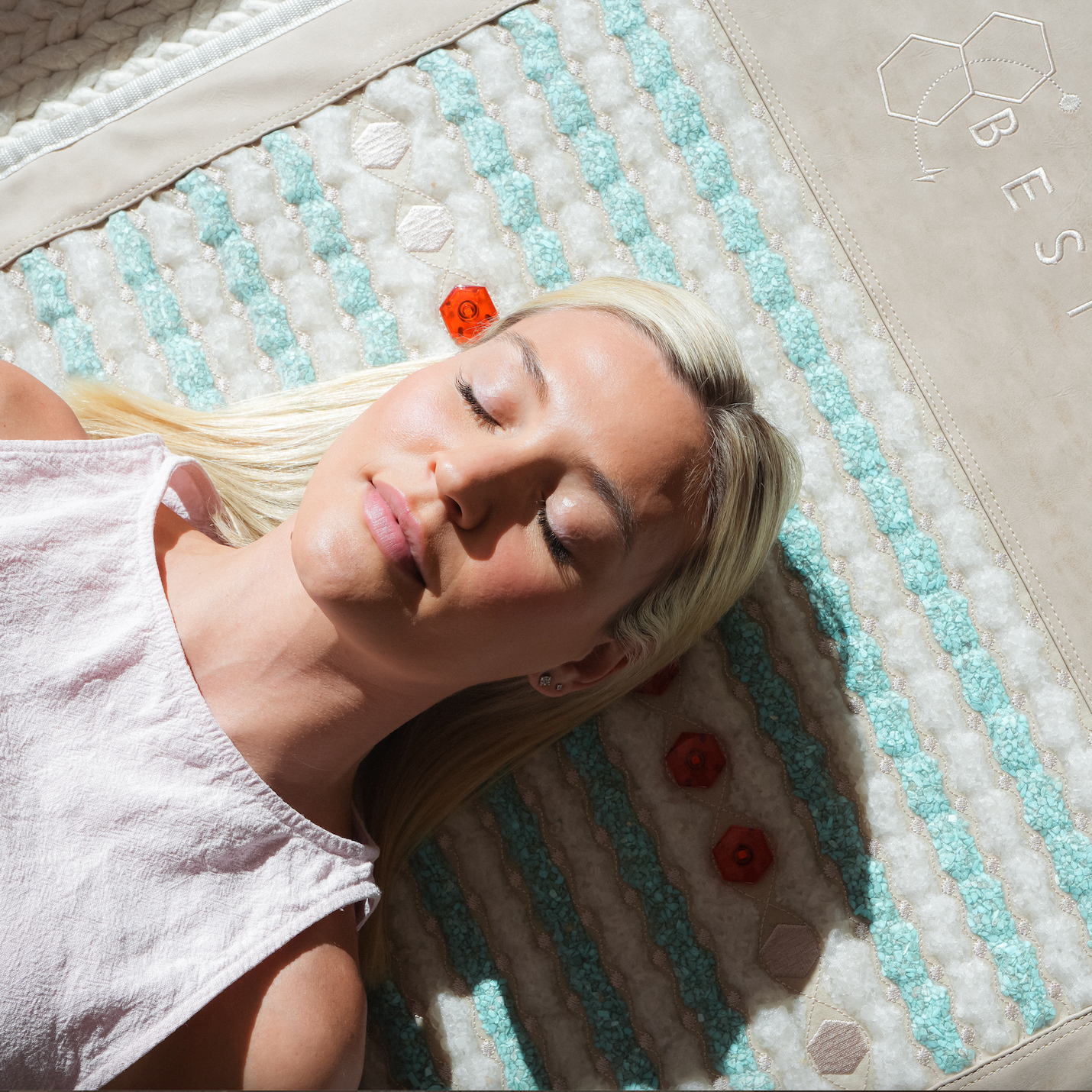 Candice laying on beige deluxe pemf mat